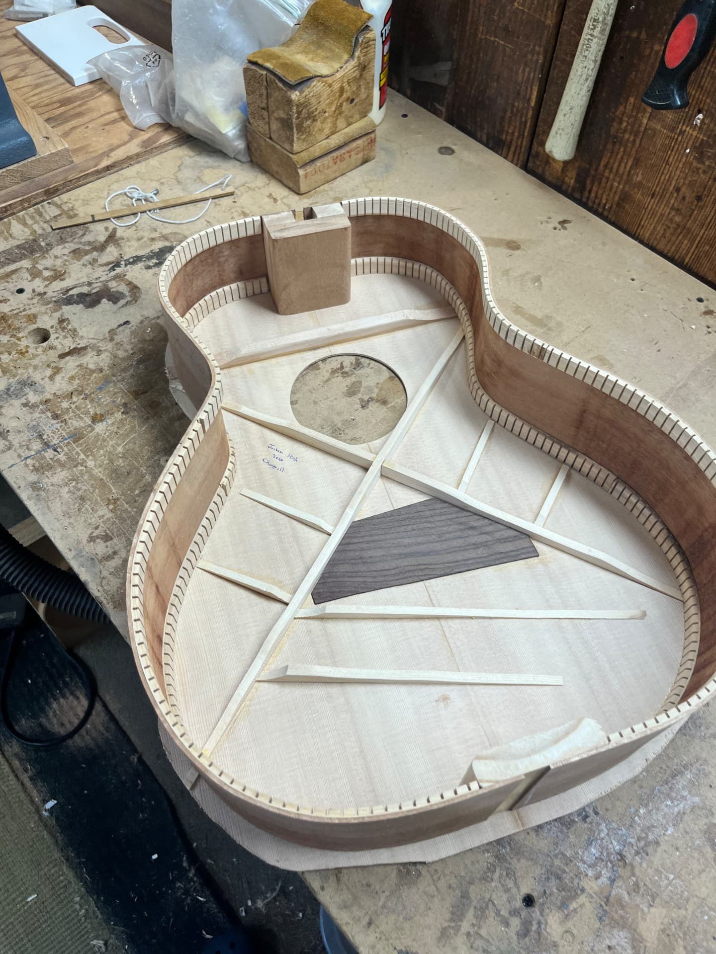 Braced spruce top and kerfed sides assembled into the guitar body on the workbench