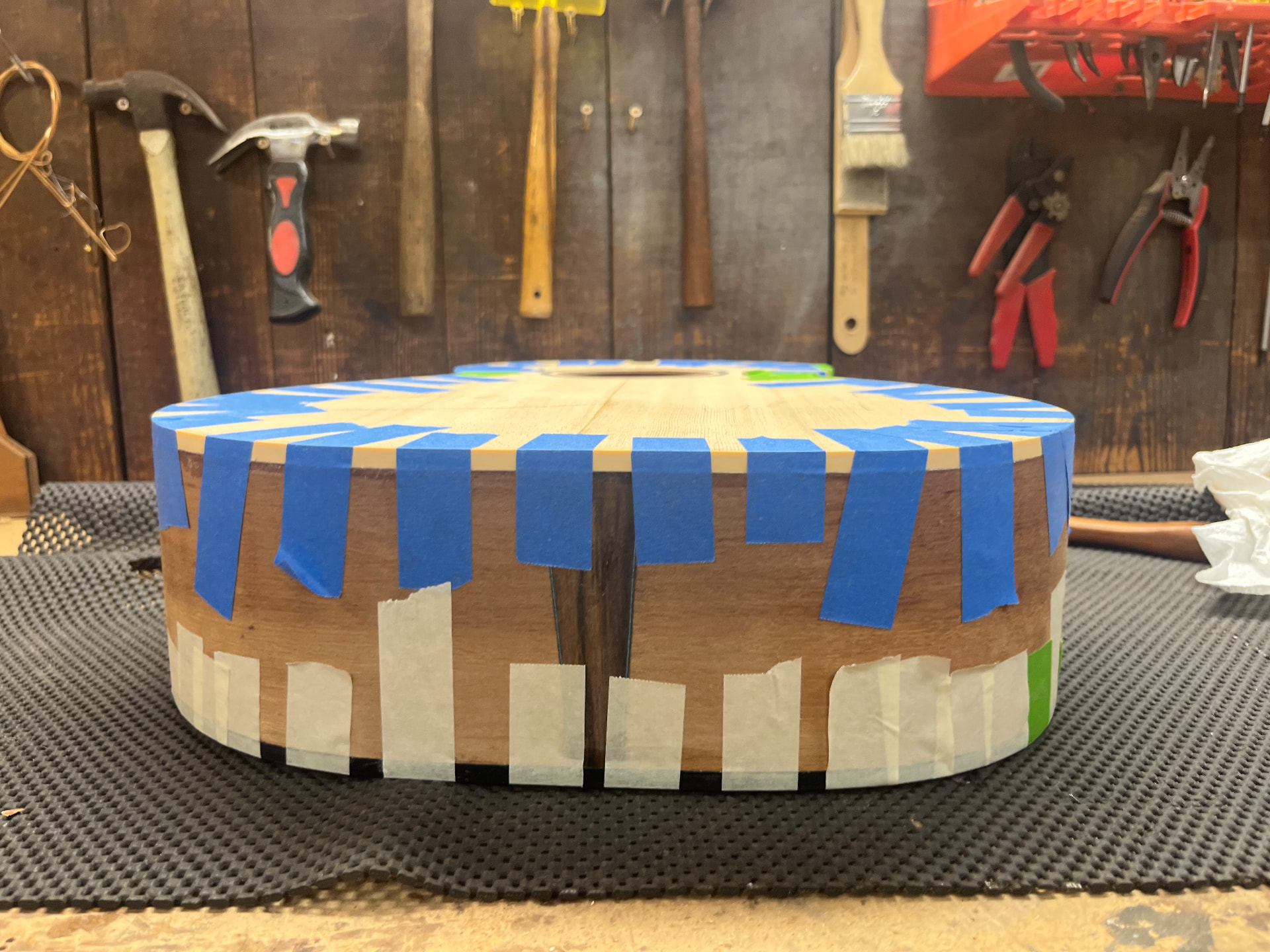 Guitar body taped up along the edges while the binding glue sets