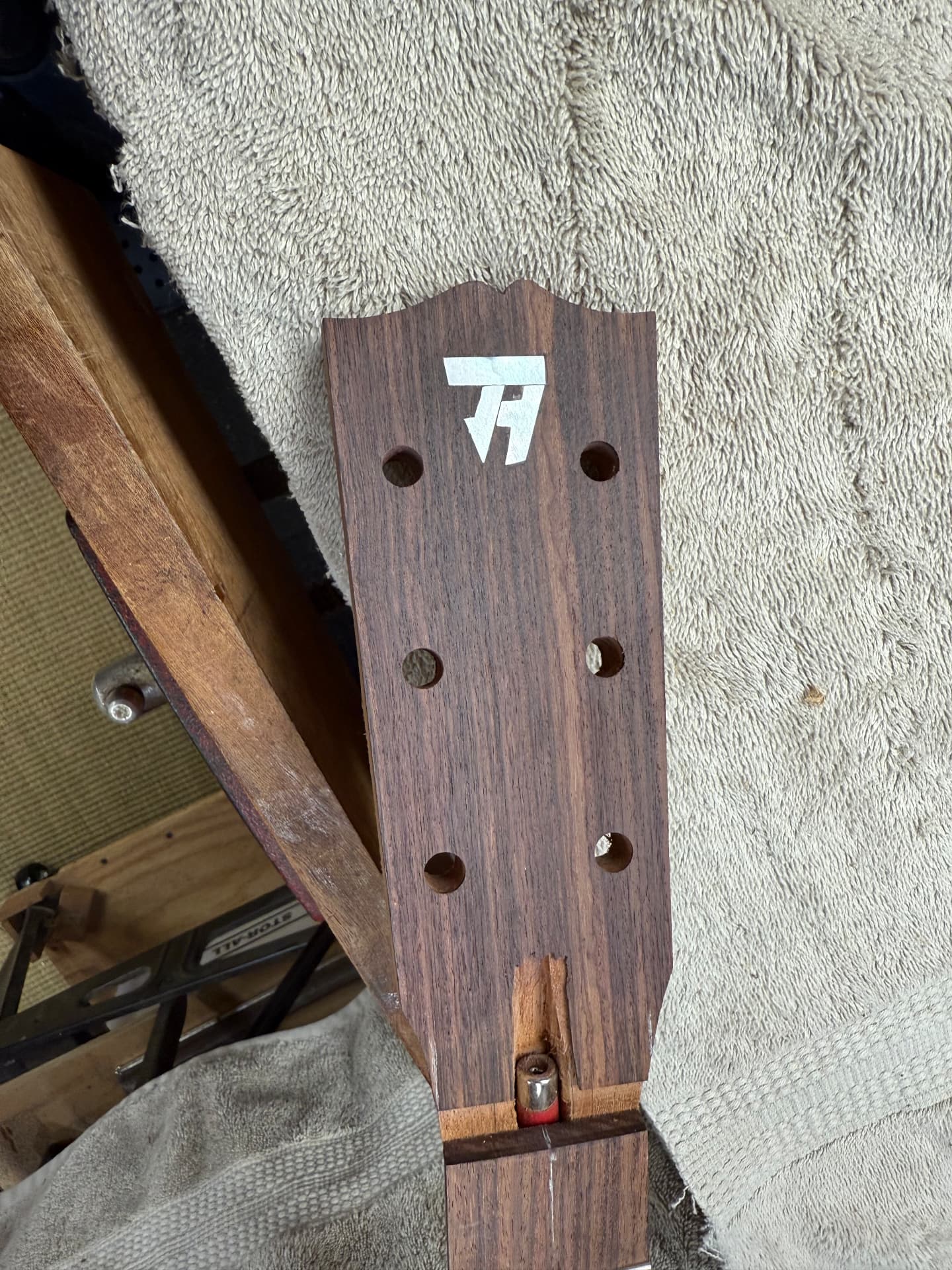 Headstock with the initials inlay being fitted