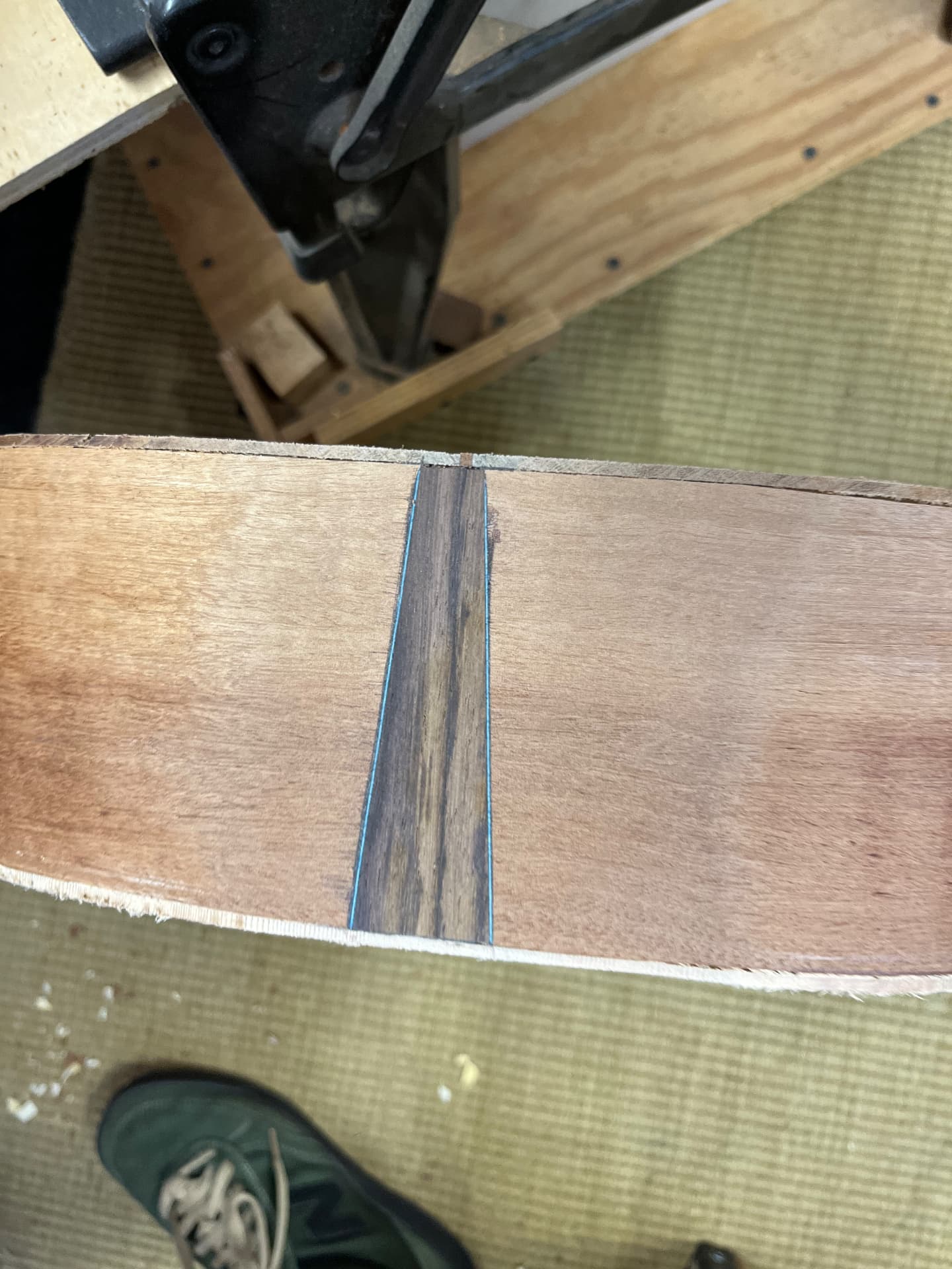 Darker wood wedge inlaid at the bottom of the body for the strap pin