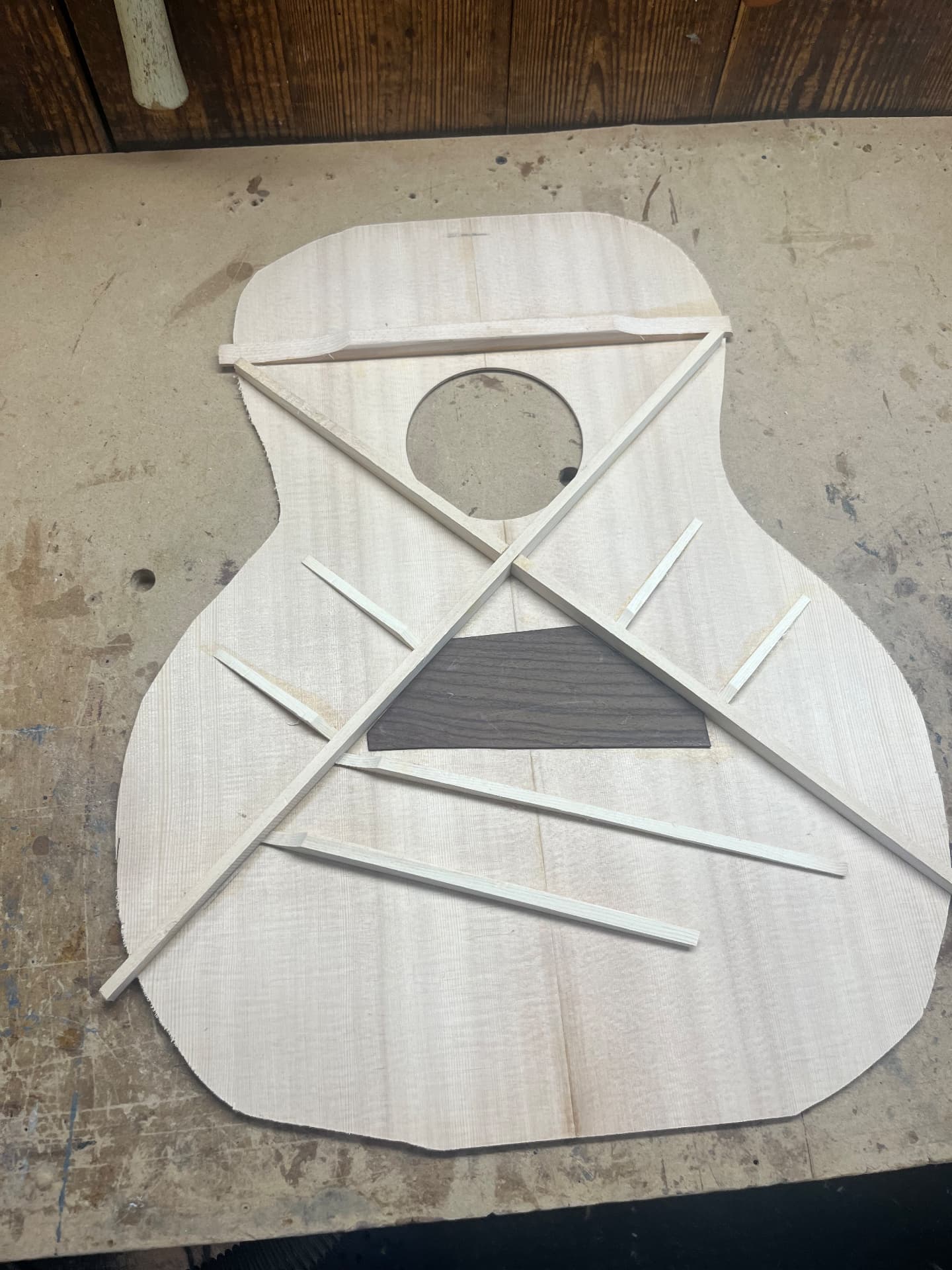 Braced spruce top with the dark bridge plate positioned beneath the X-brace